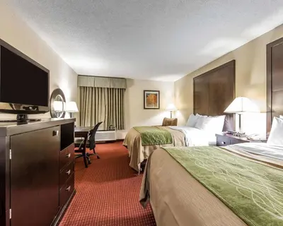 a hotel room with two beds and a flat screen tv at Quality Inn & Suites Portsmouth in Rosemount