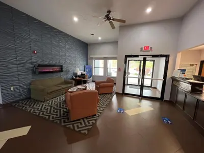 a living room with a couch and chairs and a fireplace at Quality Inn & Suites Portsmouth in Rosemount