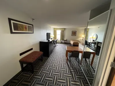 a hotel room with a bed and a table and chairs at Quality Inn & Suites Portsmouth in Rosemount