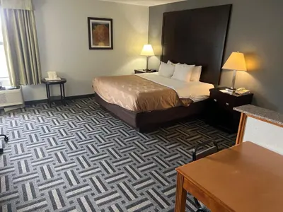 a hotel room with a bed and a desk at Quality Inn & Suites Portsmouth in Rosemount