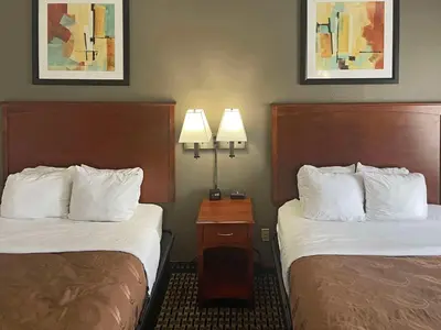 two beds in a hotel room with two lamps at Quality Inn & Suites Cincinnati Sharonville in Sharonville