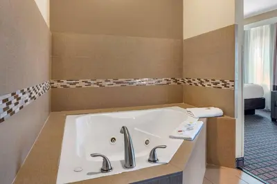 a bathroom with a bath tub with two faucets at Comfort Inn & Suites Cincinnati Uptown Clifton in Cincinnati