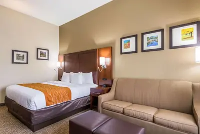 a hotel room with a bed and a couch at Comfort Inn & Suites Dayton North in Dayton