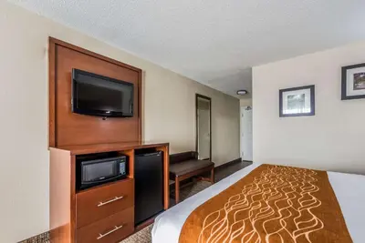 a hotel room with a bed and a flat screen tv at Comfort Inn & Suites Dayton North in Dayton