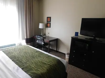 a hotel room with a bed and a flat screen tv at Comfort Inn St Clairsville in Saint Clairsville