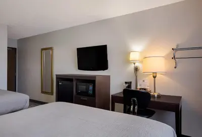 a hotel room with a bed and a desk and a tv at Quality Inn Hall of Fame in Canton