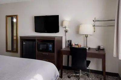 a hotel room with a bed and a desk and a television at Quality Inn Hall of Fame in Canton