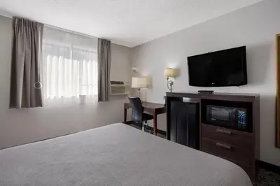 a hotel room with a bed and a flat screen tv at Quality Inn Hall of Fame in Canton