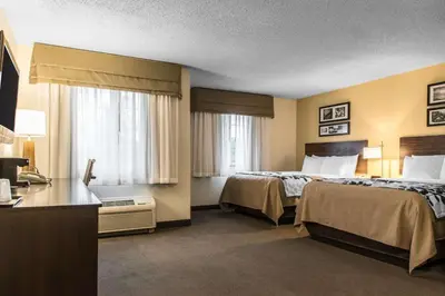 a hotel room with two beds and a desk at Sleep Inn & Suites Pittsburgh Airport in Imperial