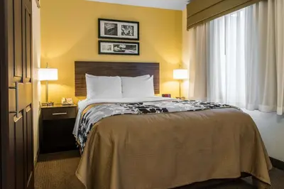 a hotel room with a bed and two lamps at Sleep Inn & Suites Pittsburgh Airport in Imperial