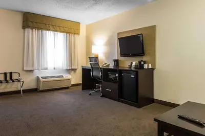 a hotel room with a television and a desk with a chair at Sleep Inn & Suites Pittsburgh Airport in Imperial