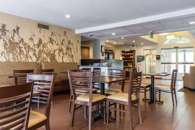 a dining room with tables and chairs in a restaurant at Sleep Inn & Suites Pittsburgh Airport in Imperial