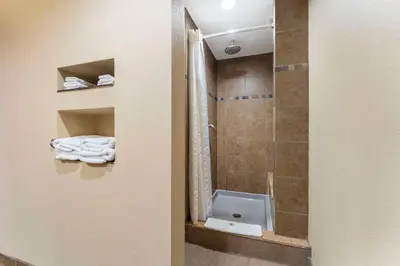 a bathroom with a shower with a toilet and a sink at Comfort Suites Monaca in Monaca
