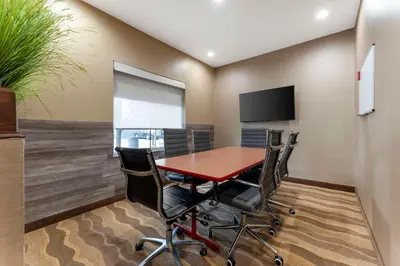 a conference room with a table and chairs and a tv at Comfort Suites Monaca in Monaca