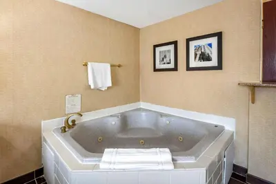 a large white tub in a bathroom with towels at Comfort Inn Meadowlands in Washington