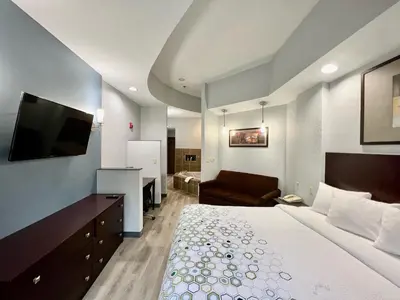 a hotel room with a bed and a flat screen tv at HomeTowne Studios & Suites by Red Roof Washington in Washington