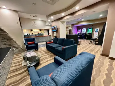 a lobby with blue couches and a bar at HomeTowne Studios & Suites by Red Roof Washington in Washington