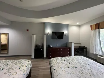 a bedroom with a bed and a flat screen tv at HomeTowne Studios & Suites by Red Roof Washington in Washington