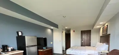 a room with a bed and a refrigerator at HomeTowne Studios & Suites by Red Roof Washington in Washington