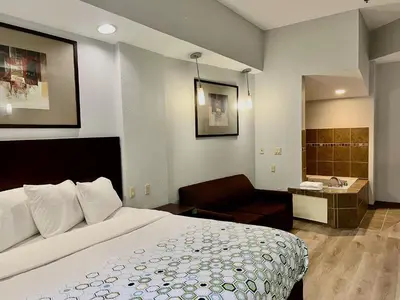 a hotel room with a bed and a bathroom at HomeTowne Studios & Suites by Red Roof Washington in Washington