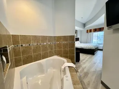 a large bath tub in a bathroom with a bedroom at HomeTowne Studios & Suites by Red Roof Washington in Washington