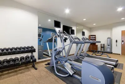 a gym with treadmills and machines in a room at Comfort Inn Barboursville near Huntington Mall area in Barboursville