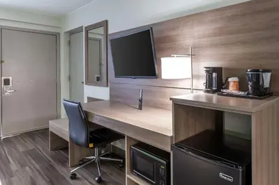 a room with a desk with a television and a chair at Quality Inn Ripley in Ripley