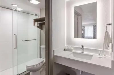 a bathroom with a toilet and a sink and a mirror at Quality Inn Ripley in Ripley