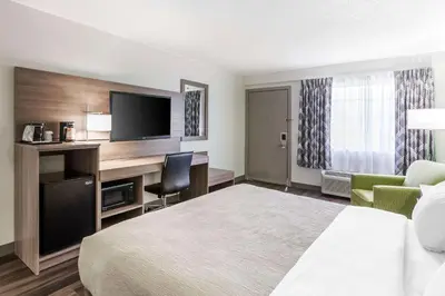a hotel room with a bed and a desk with a television at Quality Inn Ripley in Ripley