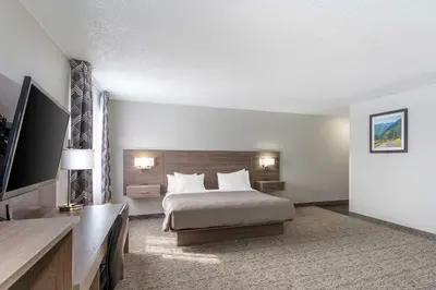 a hotel room with a bed and a flat screen tv at Quality Inn Ripley in Ripley