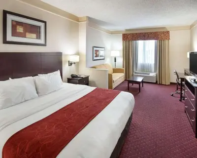 a hotel room with a large bed and a desk at Comfort Suites Parkersburg South in Mineralwells