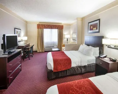 a hotel room with two beds and a flat screen tv at Comfort Suites Parkersburg South in Mineralwells