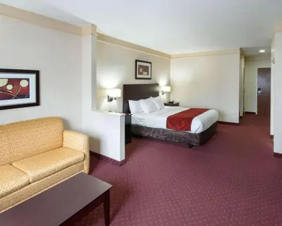 a hotel room with a bed and a couch at Comfort Suites Parkersburg South in Mineralwells
