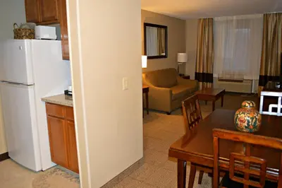 a kitchen and living room with a refrigerator and a table at Wyndham Garden Hotel Cross Lanes Charleston in Charleston