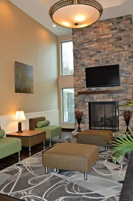 a living room with a fireplace and a tv at Wyndham Garden Hotel Cross Lanes Charleston in Charleston