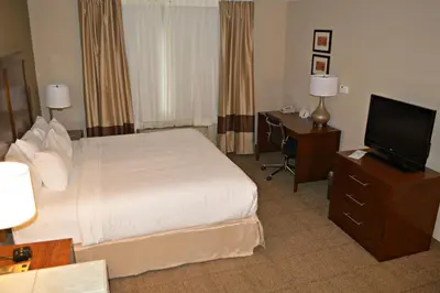 a hotel room with a bed and a flat screen tv at Wyndham Garden Hotel Cross Lanes Charleston in Charleston