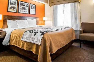 a hotel room with a bed and a chair at Quality Inn Bridgeport-Clarksburg in Bridgeport