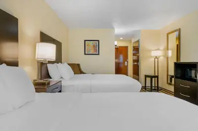a hotel room with two beds and a television at Comfort Inn & Suites Triadelphia - Wheeling in Triadelphia