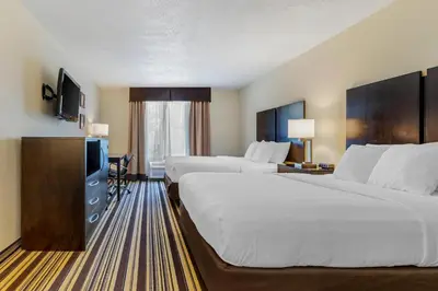 a hotel room with two beds and a television at Comfort Inn & Suites Triadelphia - Wheeling in Triadelphia