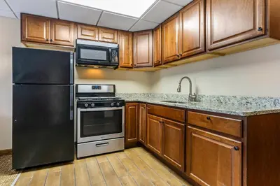 a kitchen with stainless steel appliances and wooden cabinets at Comfort Inn & Suites Triadelphia - Wheeling in Triadelphia