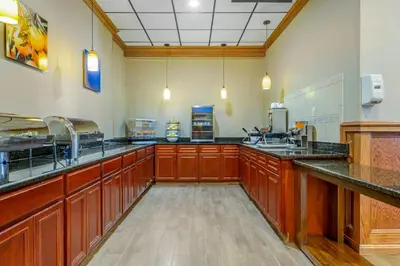 a large kitchen with wooden cabinets and black counter tops at Comfort Inn & Suites Triadelphia - Wheeling in Triadelphia