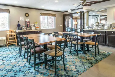 a dining room with tables and chairs on a rug at Comfort Inn Weirton - Steubenville in Weirton