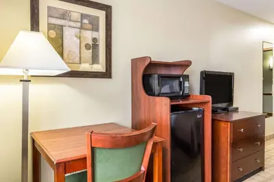 a room with a desk and a small table with a television at Quality Inn I-74 Batesville in Batesville