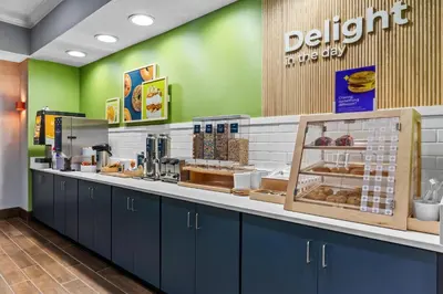 a doughnut shop with blue cabinets and green walls at Spark by Hilton Cincinnati Fairfield in Forest Park