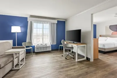 a hotel room with a bed and a desk with a television at Spark by Hilton Cincinnati Fairfield in Forest Park