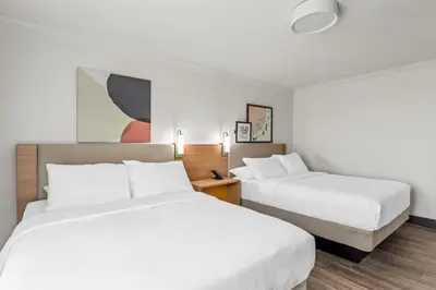 two beds in a hotel room with white sheets at Spark by Hilton Cincinnati Fairfield in Forest Park