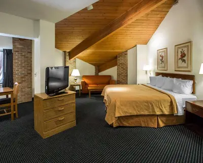a hotel room with a bed and a flat screen tv at Quality Inn Dundee in Dundee