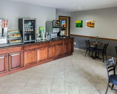 a restaurant with a counter and a table and chairs at Quality Inn Dundee in Dundee