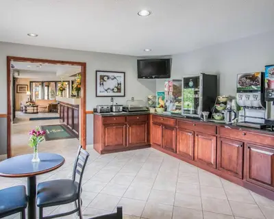 a kitchen with a counter and a table with chairs at Quality Inn Dundee in Dundee