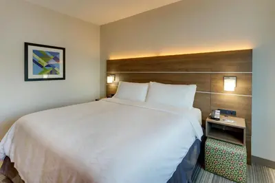 a hotel room with a large bed and a side table at Holiday Inn Express - Cincinnati North - Monroe by IHG in Monroe